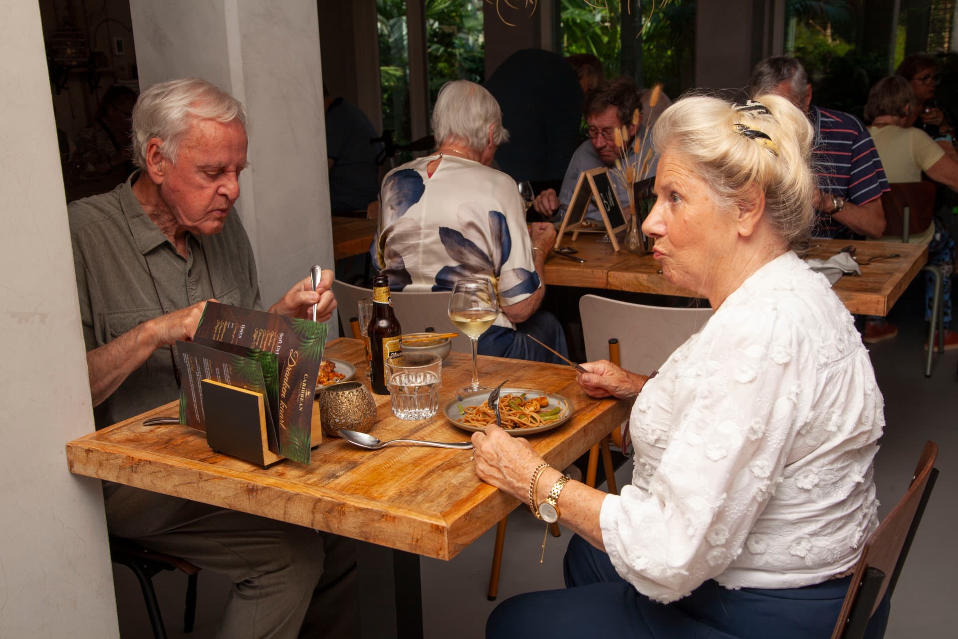 Echtpaar bekijkt de drankenkaart tijdens het diner